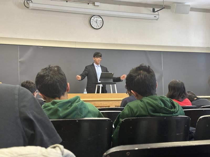 A student delivering a speech to a full room